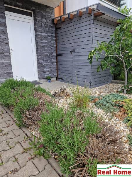 Garden with flowers and paving at a family house on Brusnicova Street in Chorvátsky Grob.