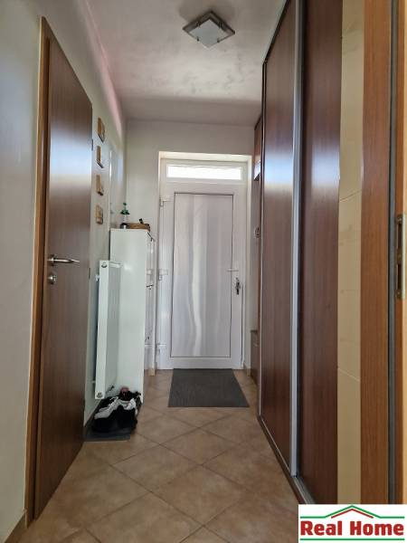 Entrance hallway in a family house with a tiled floor and a built-in wardrobe.