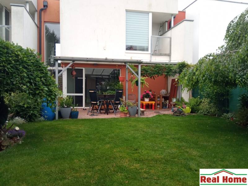 The garden of a family house on Brusnicova Street in Chorvátsky Grob with a terrace and greenery.