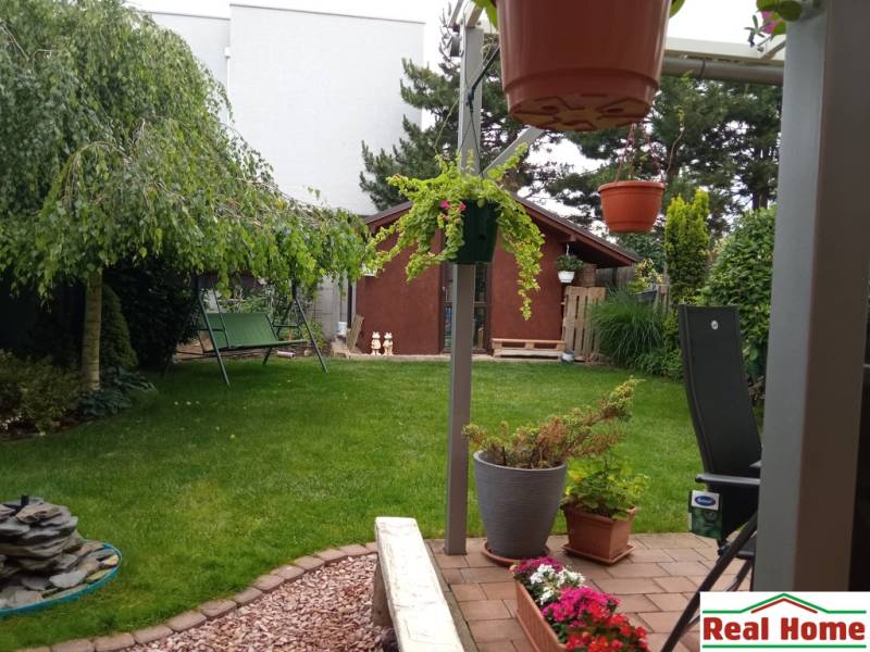 The garden at the family house on Brusnicová Street in Chorvátsky Grob with a swing and a gazebo.