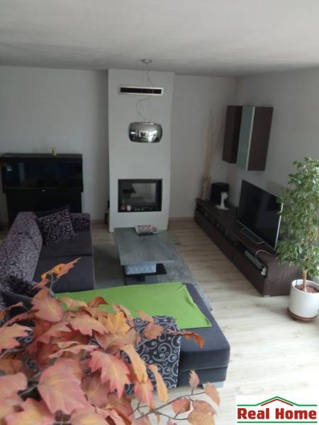 Living room in a family house with a fireplace, sofa set, and decorations.