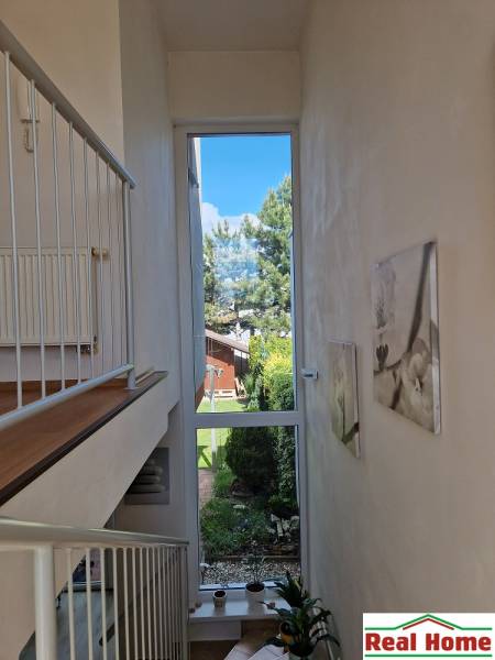 Interior of a family house with a large window, garden view, and staircase.