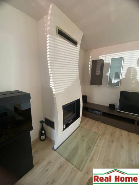 Interior of a family house with a fireplace and wooden flooring.