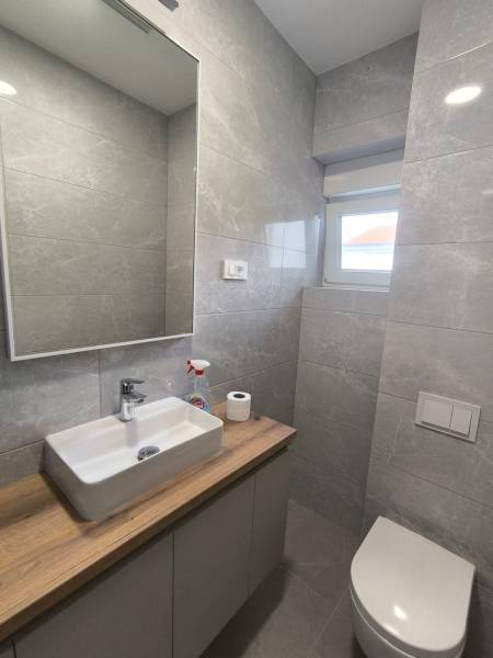 Bathroom in a 4-room apartment with a sink, cabinet, mirror, and toilet.