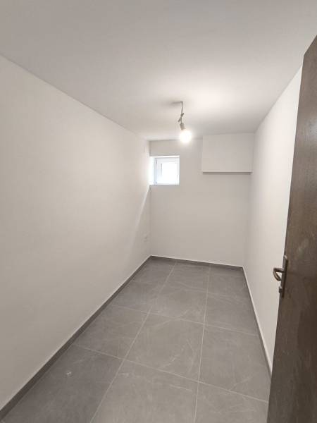 A small room with white walls and a gray floor in a 4-room apartment.
