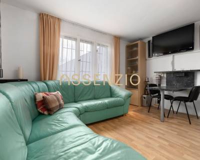 The interior of a family house with a corner sofa and a television on the wall.