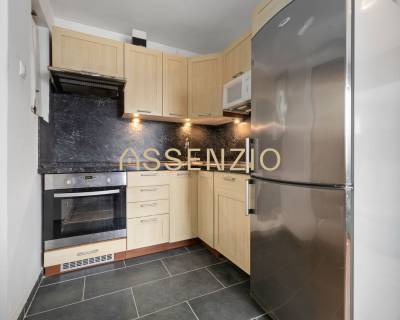 A kitchen in a family house with wooden cabinets and a stainless steel refrigerator.