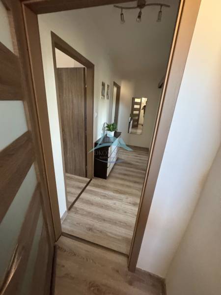 Hallway of a 3-room apartment with wooden flooring and entrances to the rooms.