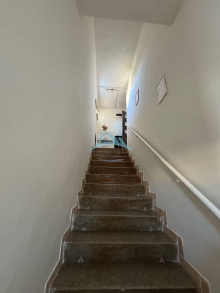 A staircase with white walls leading to an apartment in a 3-room flat.