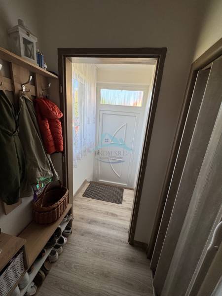 Hallway of a 3-room apartment with coat racks, a shoe cabinet, and doors with a transom window.