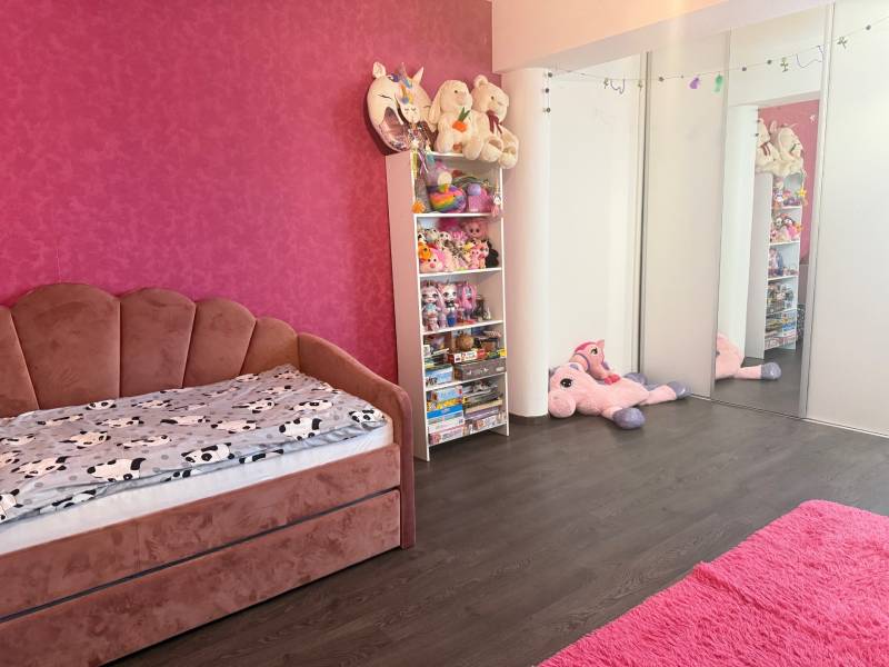 Children's room in a 4-room apartment with pink furniture and toys.
