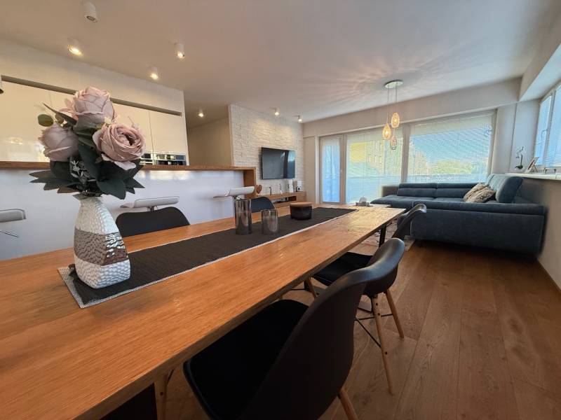Dining room with flowers in a 4-room apartment and a view of the living room.