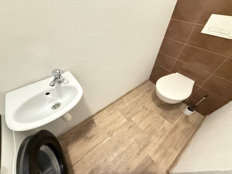 A bathroom in a 4-room apartment with a built-in sink and a washing machine.