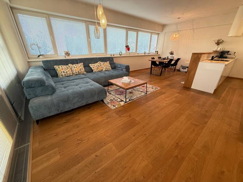 Living room in a 4-room apartment with furniture and wooden flooring.