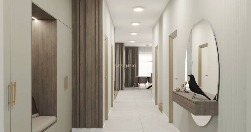 A hallway in a family house with wood and a mirror on the wall, leading to the living room.