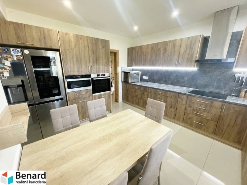 A family house kitchen with wooden furniture and built-in appliances.
