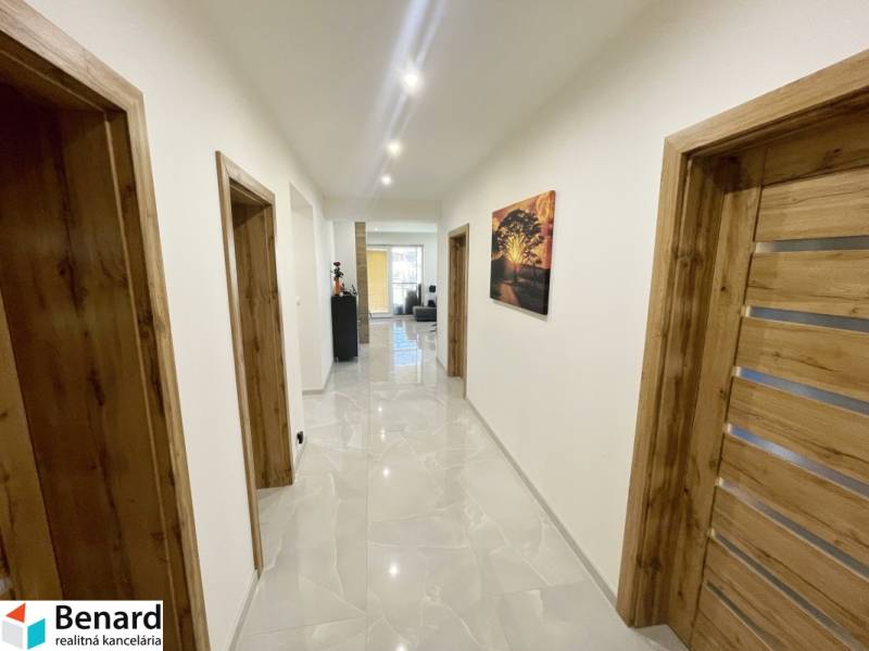 A hallway with wooden doors and a tiled floor in a family house.
