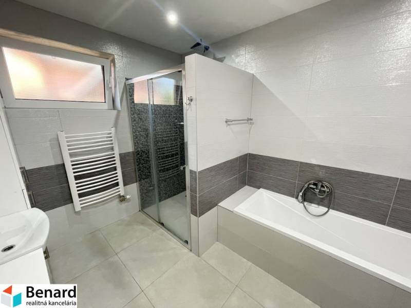 Bathroom with a bathtub and a shower in a family house.