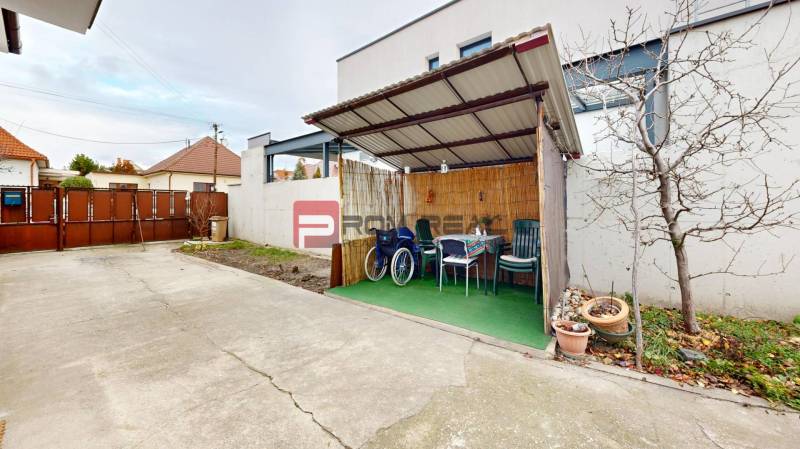 The courtyard of a family house on Farebna Street in Bratislava II with a garden shelter.