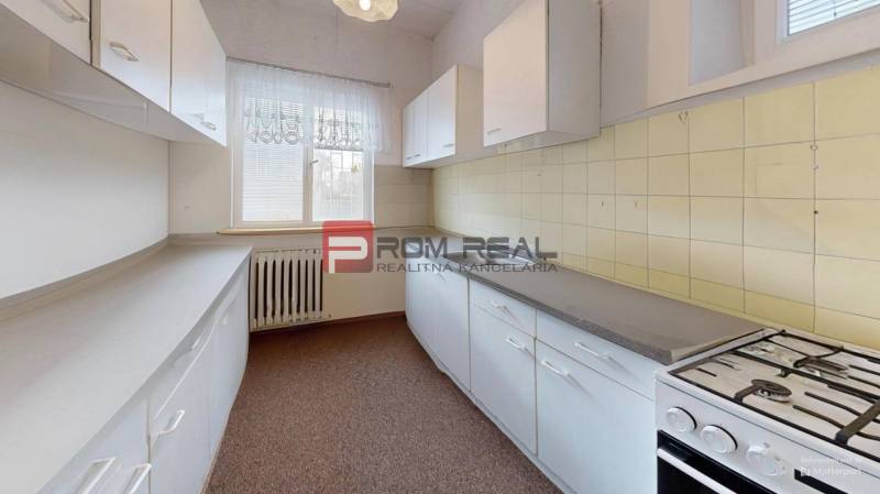 A kitchen in a family house with a gas stove and plenty of storage space.