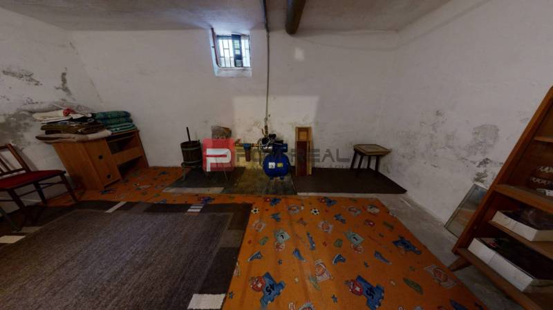 Basement of a family house with a small window, carpet, and interior furnishings including an armchair.