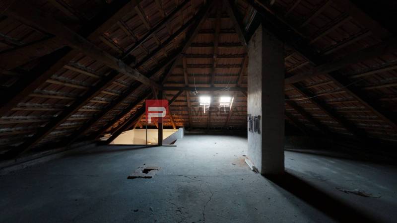 Attic space in a family house with wooden beams and skylights.