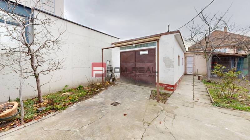 The yard at the family house on Farebna Street in Bratislava II with a garage and trees.