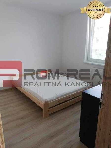 Simple bedroom with light, bed, and furniture in a two-room apartment on Slavomírova Street.