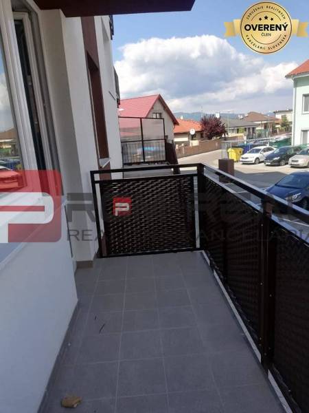 The balcony of a 2-room apartment on Slavomírova Street, overlooking the surrounding buildings and cars.