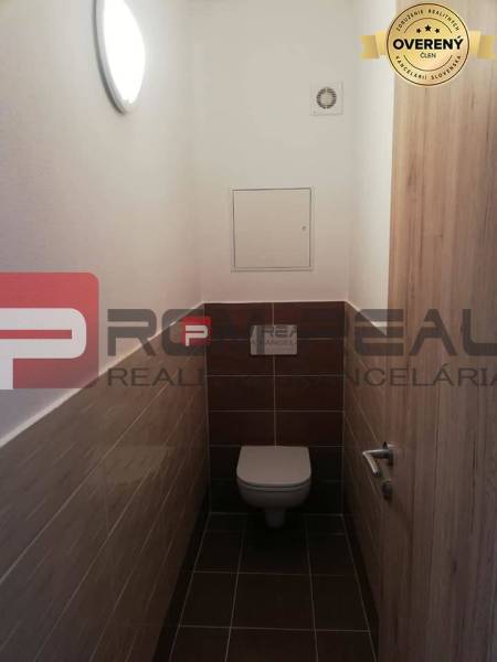 A simple toilet with tiled walls, part of a 2-room apartment on Slavomírova Street.