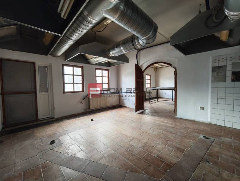 A space with tiles and ventilation pipes, suitable for commercial premises.
