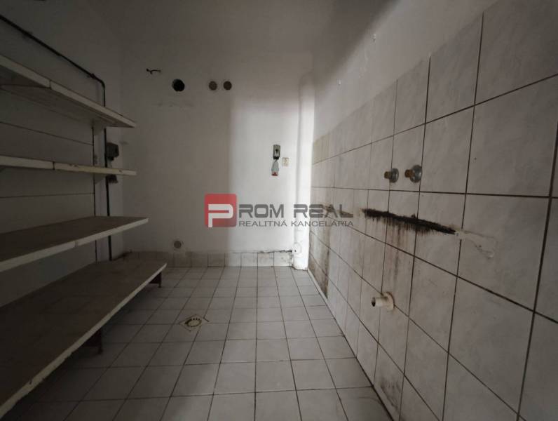 Retail spaces with white tiles and wall shelves.