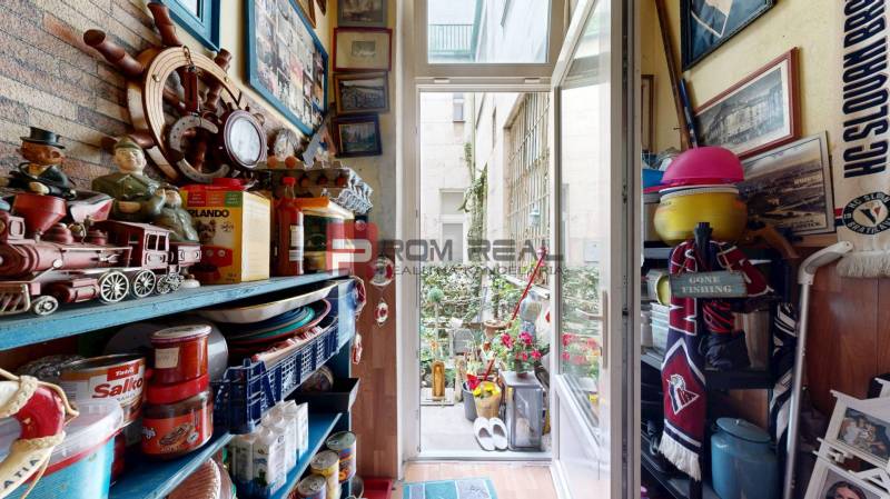 A covered balcony in a 2-room apartment with decorations and a view of the inner courtyard.