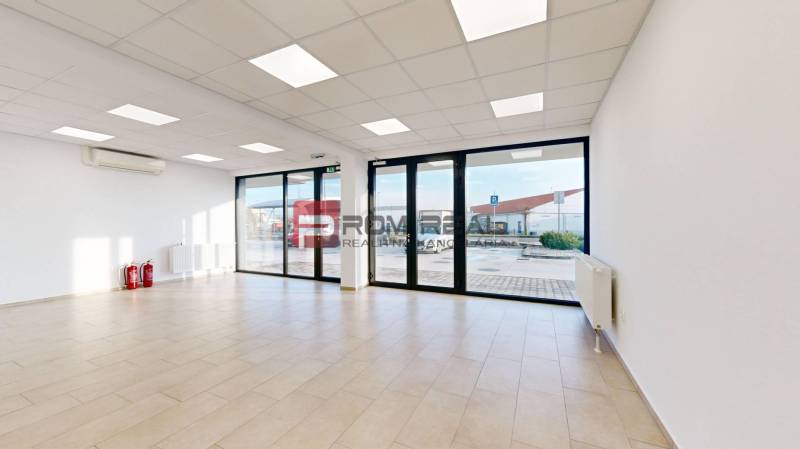 Empty commercial spaces with large windows and flooring.