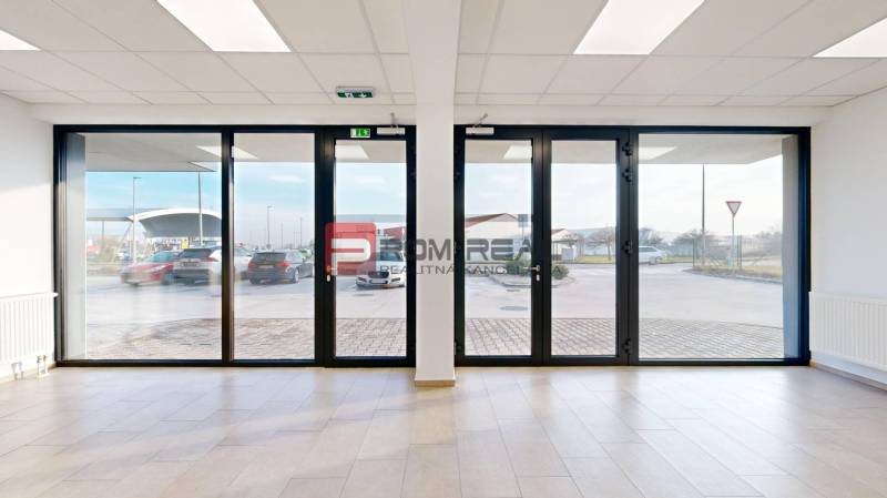 Spacious commercial spaces with large glass doors to the exterior and wooden floors.