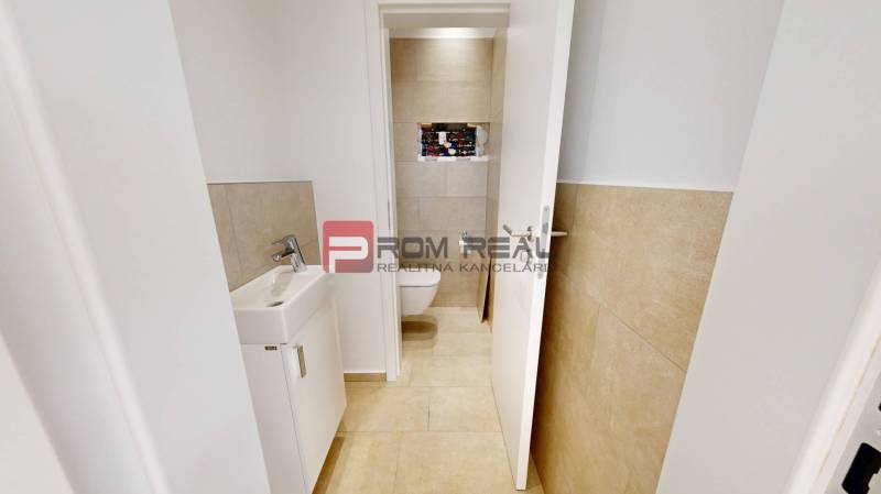 Interior of commercial premises with a toilet, sink, and tiles, suitable for rent.