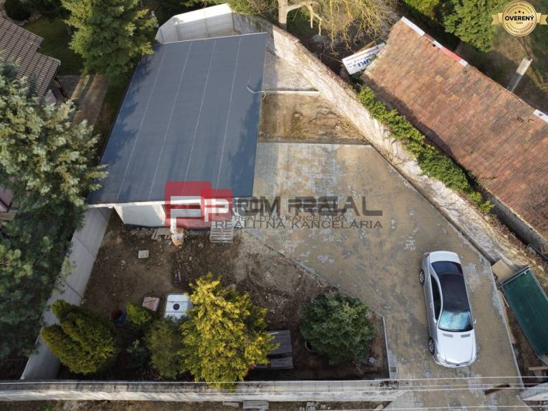 Aerial view of a family house yard in Pezinok with a parked car and a garage.