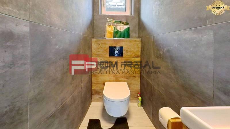 Bathroom in a family house with a toilet, sink, and storage space.