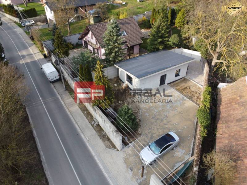 A family house in Pezinok with a garden and a driveway, with a car in the yard.