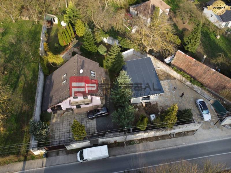 A family house in Píla with a garden, driveway, and parking lot, surrounded by greenery.
