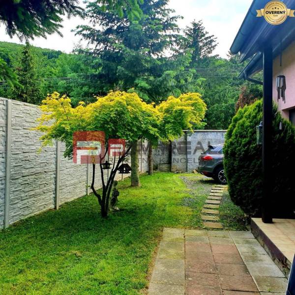 A family house in the village of Píla with a garden, a car, and unique trees.