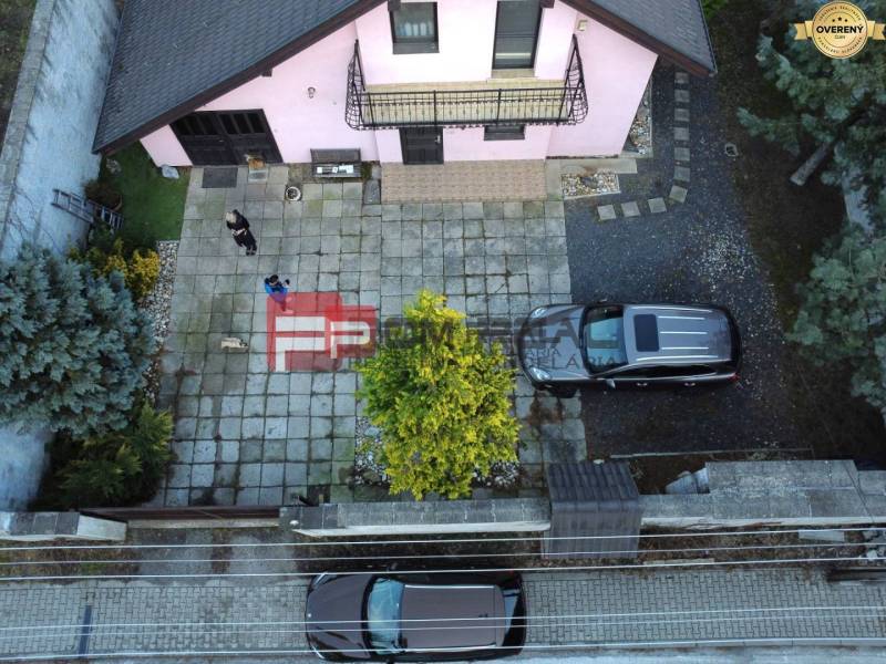 A family house in Píla with a spacious yard, parked cars, and a well-maintained garden.
