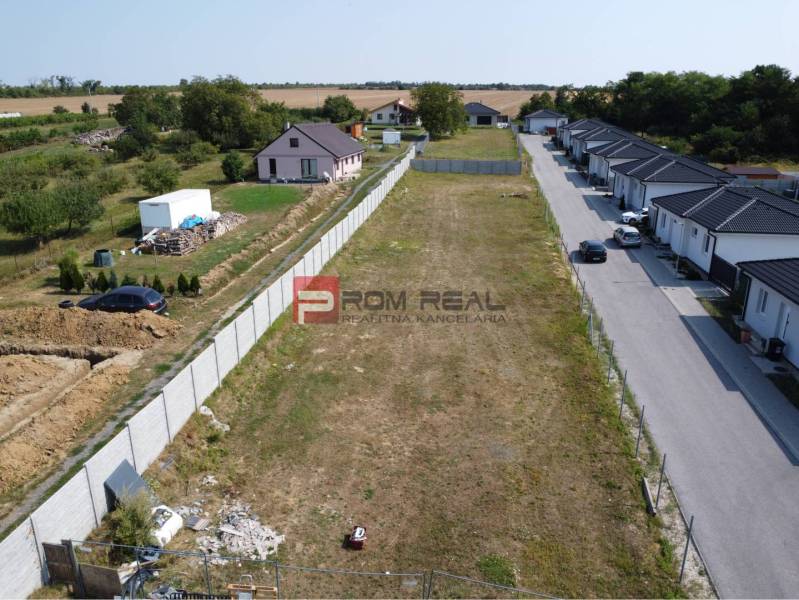 Plots - housing in Štefanová, next to an empty parcel, surrounded by rural houses and greenery.