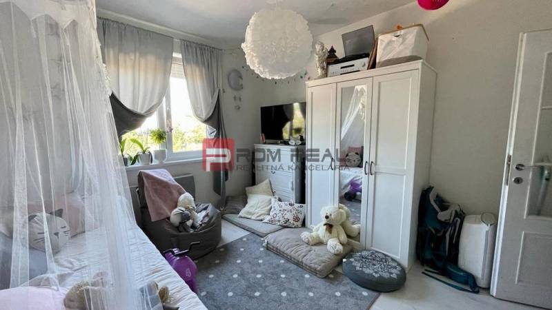 Children's room in a 3-room apartment with toys, a bed, and a wardrobe.
