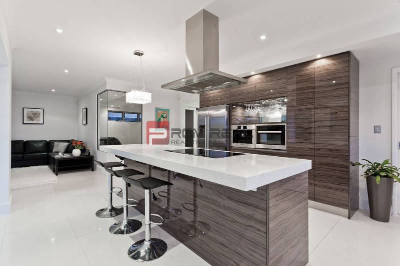 Modern kitchen with an island in a 3-room apartment. Elegant solution with bar stools.