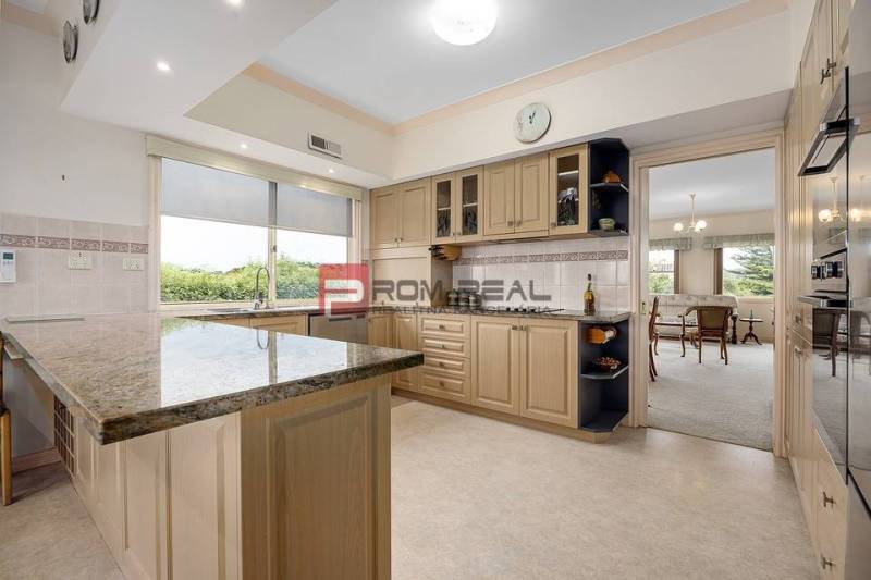 A spacious kitchen with an island and a dining table in a 3-room apartment.