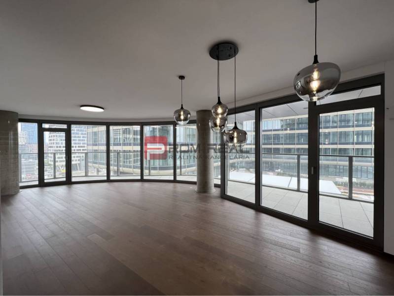 Interior of commercial spaces with large windows and modern lighting.