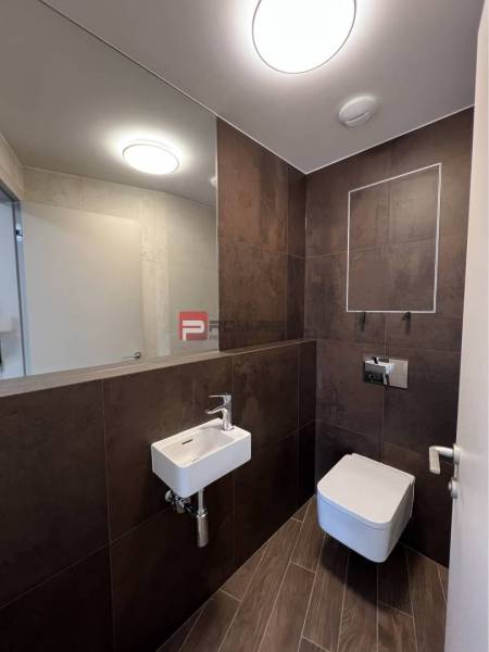 Bathroom commercial spaces with a sink, mirror, and toilet.