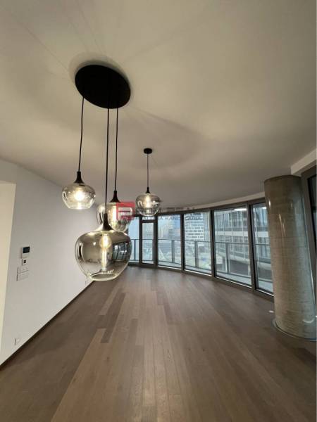 Pendant lights in commercial spaces with parquet flooring and large windows.