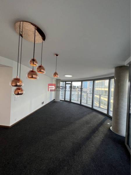 Commercial spaces with panoramic windows, dark carpet, and decorative lights.